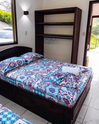 a bedroom with a bed with a colorful quilt at FLOR DE PARAISO BUNGALOWS in Montezuma