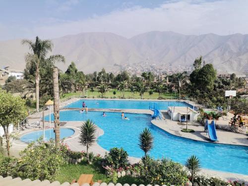 a pool at a resort with people swimming in it at Mi Pequeño Club (Country Club) in Lima