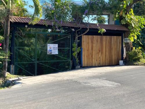 a building with a gate next to a street at FLOR DE PARAISO BUNGALOWS in Montezuma