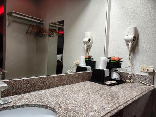 um balcão de casa de banho com um lavatório e um espelho em Express Inn Hobby Airport em Houston