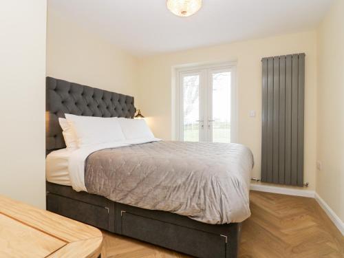 a bedroom with a large bed and a window at How Hill Farm Cottage in Penrith