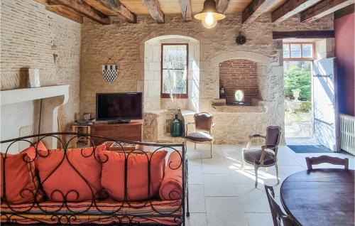 a living room with a couch and a tv in a room at Les Lumas in Taizé-Aizie