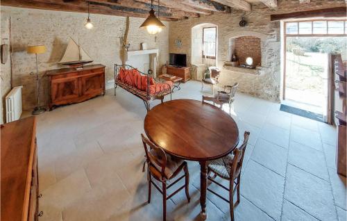 a living room with a wooden table and chairs at Les Lumas in Taizé-Aizie