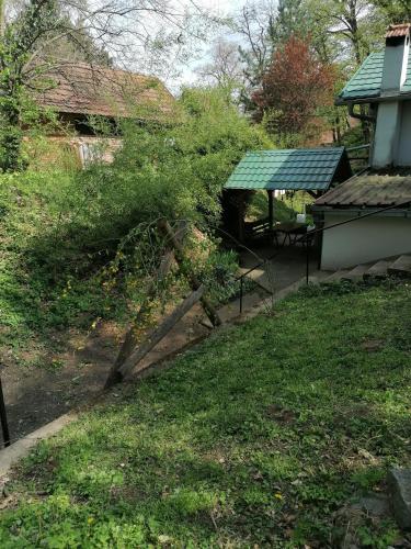 a garden with a bush next to a house at Čarobna koliba M&M in Čortanovci