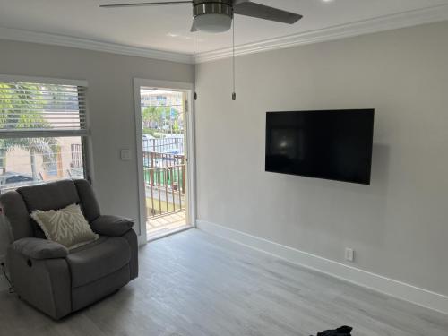 a living room with a chair and a flat screen tv at SEA ECHO APPARTMENT MOTEL in Fort Lauderdale