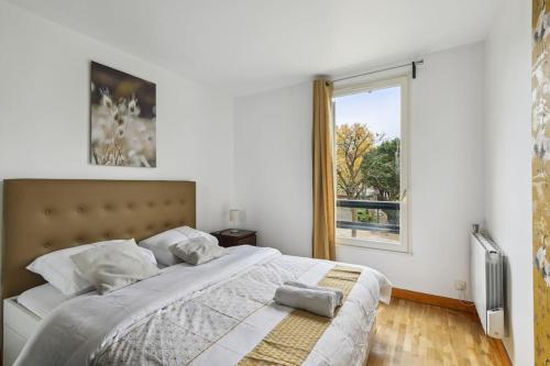 - une chambre avec un grand lit et une fenêtre dans l'établissement "Joie de vivre" - Parisian Spacious & Charming flat, à Asnières-sur-Seine