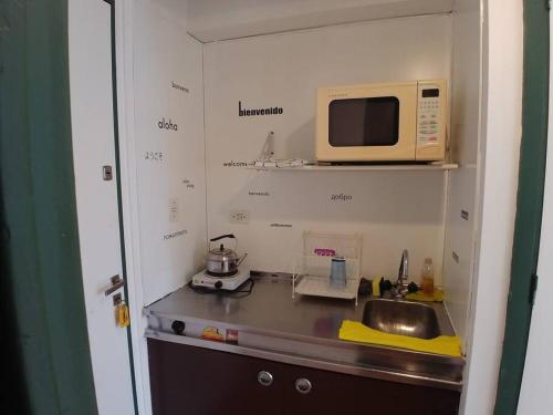 una pequeña cocina con fregadero y microondas en Departamento Luminoso en el centro de Buenos Aires en Buenos Aires
