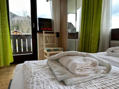 a bedroom with a bed with towels on it at Wohlfühlapartment Dachsteinblick in Bad Goisern