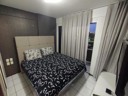 um pequeno quarto com uma cama e uma janela em Flat 203 Clarice Lispector, Ilhotas- Teresina em Teresina