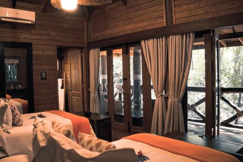 a bedroom with two beds and a large window at Platon Ecolodge in Santa Cruz de Barahona