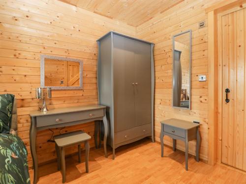 a room with a desk and a cabinet in a log cabin at The Lodge at Crossroads Farm in Bridgwater