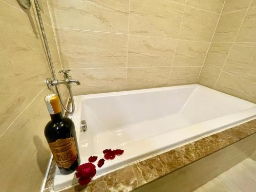 una bottiglia di vino seduta accanto alla vasca da bagno di Homestay Sapphire 4br Hạ Long View Biển a Ha Long