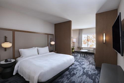 a hotel room with a bed and a television at Fairfield by Marriott Inn & Suites Waller in Waller