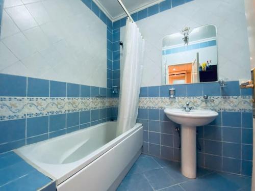 een blauw betegelde badkamer met een wastafel en een bad bij Luxury & stylish Naama bay flat at the centre of Sharm in Sharm El Sheikh