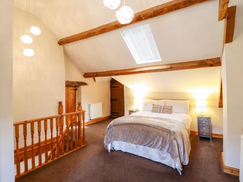 1 dormitorio con 1 cama grande en el ático en Cwm Yr Afon Cottage, en Harlech
