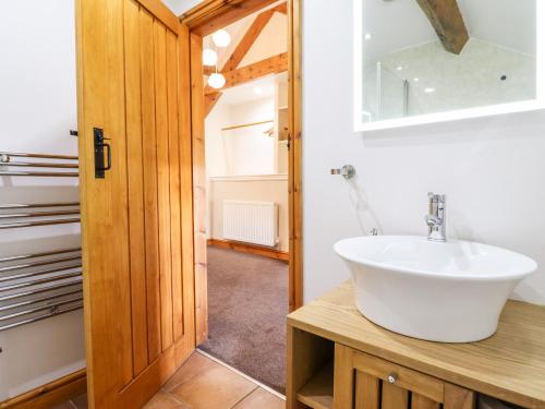 a bathroom with a sink and a mirror at Cwm Yr Afon Cottage in Harlech