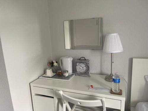 un bureau blanc avec une lampe et un réveil. dans l'établissement Single Room, Shared House, à Bristol