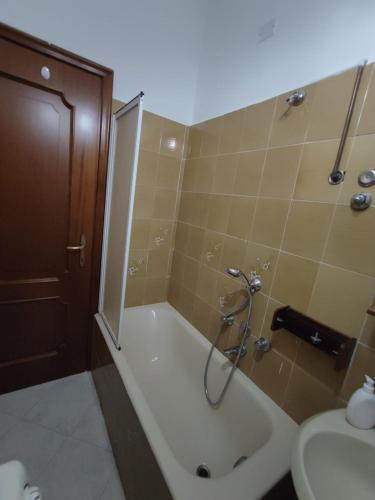 a bathroom with a shower and a tub and a sink at Angis AffittaCamere in Pero