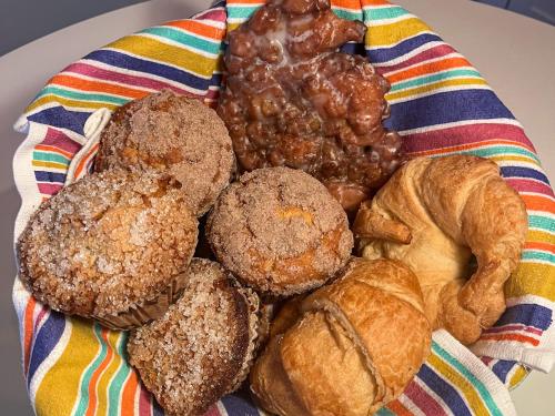a plate of muffins and croissants on a striped towel at The Richey - Pastries Delivered To You!! in Tucson