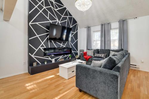 a living room with a couch and a flat screen tv at Furnished Deck and Fire Pit Home in Tobyhanna in Tobyhanna