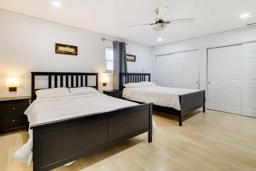 two beds in a bedroom with white walls and wood floors at Furnished Deck and Fire Pit Home in Tobyhanna in Tobyhanna
