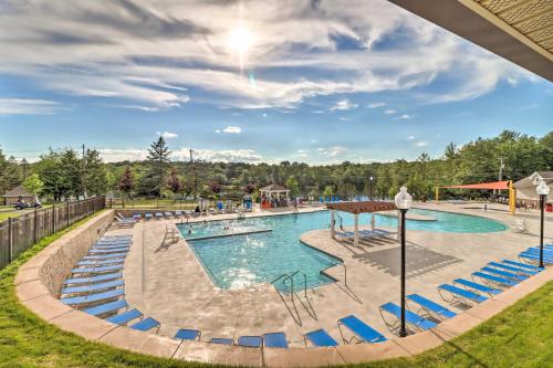 a pool at a resort with blue chairs at Furnished Deck and Fire Pit Home in Tobyhanna in Tobyhanna