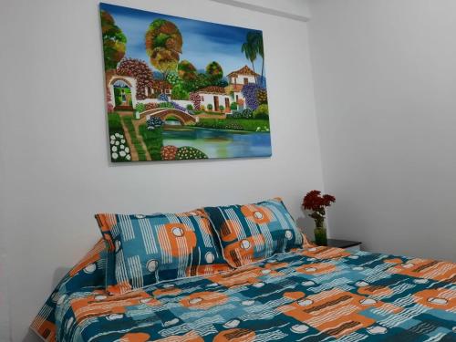 Schlafzimmer mit einem Bett mit Wandgemälde in der Unterkunft Espectacular apartamento primer piso capacidad 6 personas in Villamaría