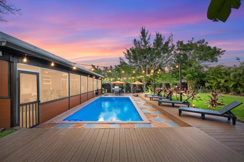 a swimming pool on a deck with benches next to a building at Unique super cozy,Bohemian Paradise with Heated Pool and positive energy in Pompano Beach