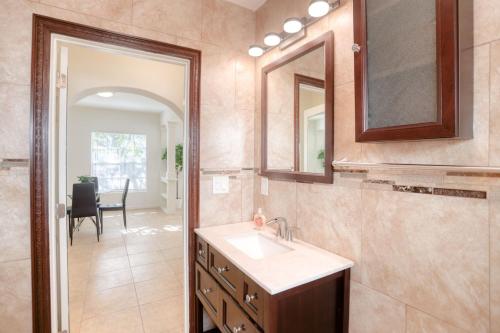 a bathroom with a sink and a mirror at Retreat to a Stylish WOW Hotel Quality Two Story Upscale 4-2 in Historic Coconut Grove in Miami