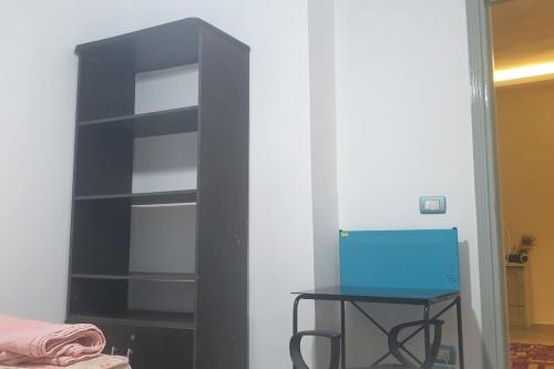 a black book shelf with a table in a room at Newly renovated cozy studio 2 min 2 SEA in Alexandria