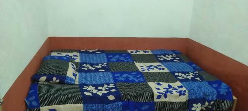 a bed with a blue and white quilt on it at SPOT ON Gagan Hotel in Khatauli