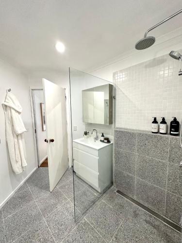 a bathroom with a shower and a sink and a mirror at Guest house on the park in Burwood East