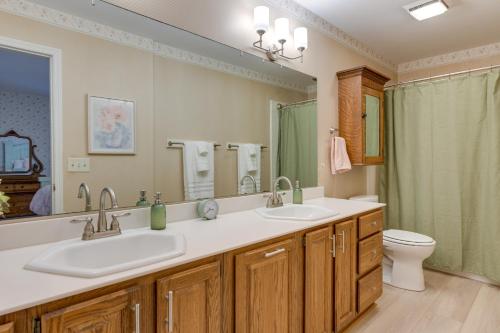 a bathroom with two sinks and a toilet and a mirror at Maggie Valley Historic Farmhouse on 5 Acres! in Maggie Valley