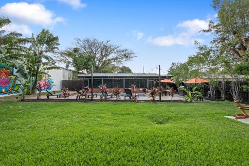 a park with benches and umbrellas in front of a building at Unique super cozy,Bohemian Paradise with Heated Pool and positive energy in Pompano Beach