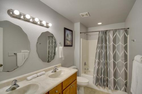 a bathroom with a sink and a toilet and a mirror at Gulfport Condo with Private Balcony - Walk to Beach! in Gulfport