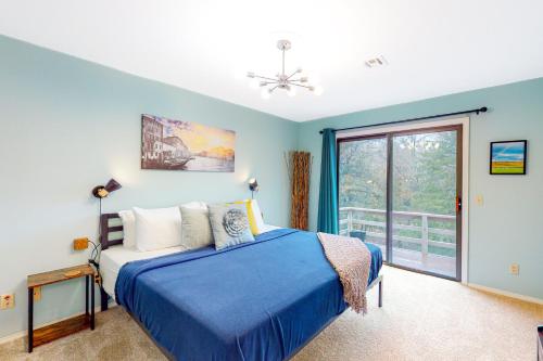 a blue bedroom with a bed and a window at Valley Retreat - Upper in Holiday Island