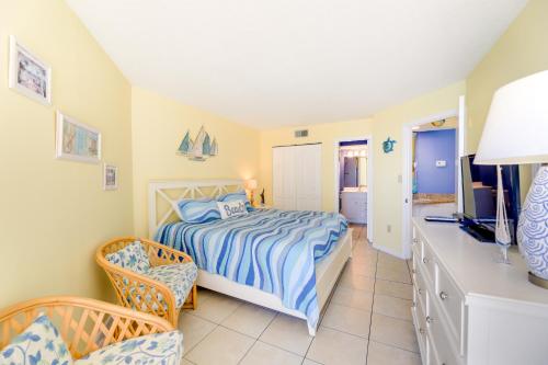 um quarto com uma cama, uma televisão e uma cadeira em North Carolina Escape with Balcony and Pool Access! em North Topsail Beach