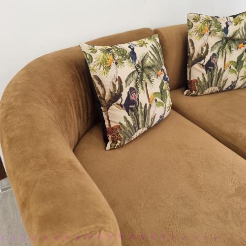 Un sofá marrón con dos almohadas. en Rumah Tropis - Lantai Dasar en Parit
