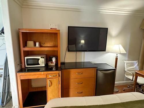 Cette chambre dispose d'un bureau, d'un four micro-ondes et d'une télévision. dans l'établissement Sunset Motel, à Santa Barbara