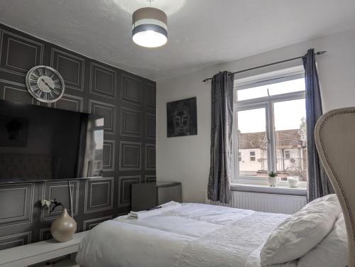 a bedroom with a bed and a clock on the wall at The Saxon Rooms in Barking