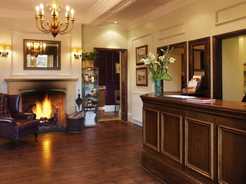 a hotel lobby with a fireplace and a bar at Three Ways House Hotel in Chipping Campden