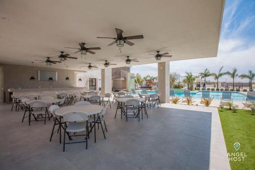 a patio with tables and chairs and a pool at Hispania - Dreamy Family Homes plus Communal Pool and Playground in La Paz