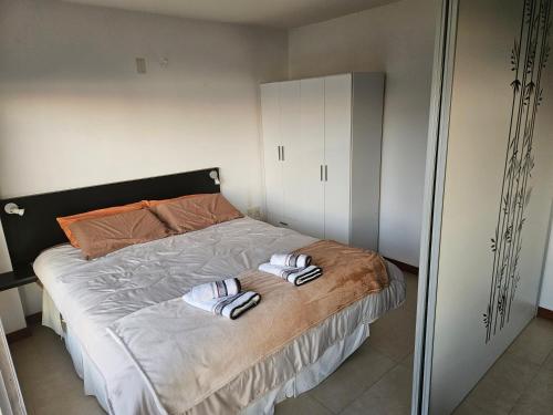 a bedroom with a bed with two slippers on it at Rambla Sacramento - Paz frente al Río in Colonia del Sacramento