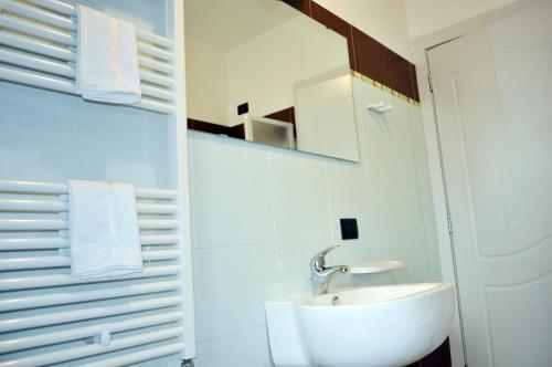 bagno bianco con lavandino e specchio di Residence Le Groane a Garbagnate Milanese