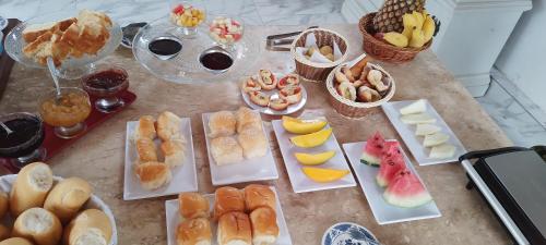 a table filled with different types of pastries and fruit at Villa ALMM in Lençóis