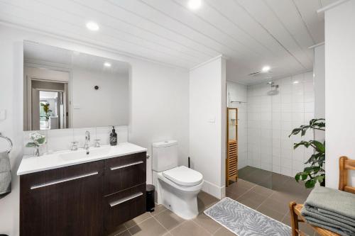 een badkamer met een toilet, een wastafel en een spiegel bij Number Eight in Lorne