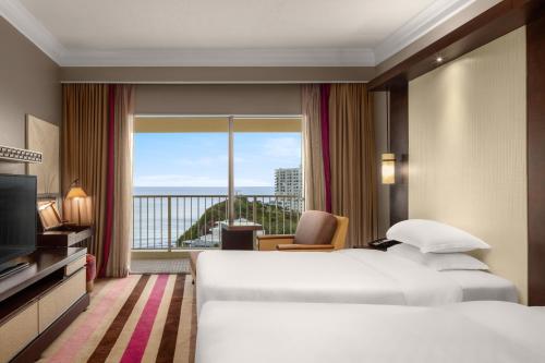 a hotel room with a bed and a large window at RIHGA Royal Laguna Guam Resort in Tamuning