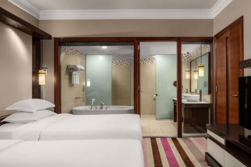 a bedroom with a bed and a tub and a sink at RIHGA Royal Laguna Guam Resort in Tamuning