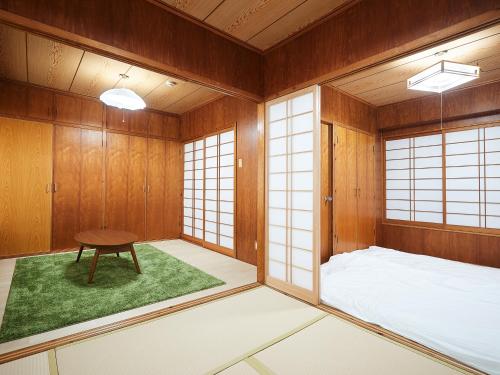 Cette chambre comprend un lit et une table. dans l'établissement Guest house II Rokumarukan, à Naha