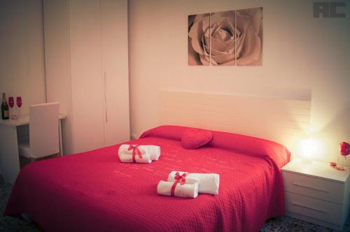 a bedroom with a red bed with two towels on it at B&Belvedere, affittacamere in San Benedetto del Tronto